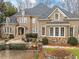 Elegant two-story brick home with a manicured lawn and a cozy front patio with a fire pit at 110 Mattison Cv, Atlanta, GA 30319