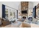 Spacious living room with stone fireplace, built-in shelving, and large windows overlooking a wooded backyard at 110 Mattison Cv, Atlanta, GA 30319