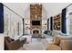 Spacious living room with stone fireplace, built-in shelving, and large windows overlooking a wooded backyard at 110 Mattison Cv, Atlanta, GA 30319