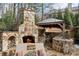 Stone outdoor kitchen and fireplace with grill, sink, and bar area at 110 Mattison Cv, Atlanta, GA 30319