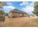 Wide backyard features a brick home with a dark roof, a fenced-in area, and a large lawn at 217 Chad Ln, Loganville, GA 30052