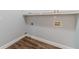Laundry room featuring wood-look floors, white cabinets, and neutral-colored walls at 217 Chad Ln, Loganville, GA 30052