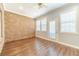Inviting sun room featuring brick accent walls, wood floors, and ample natural light from multiple windows at 217 Chad Ln, Loganville, GA 30052
