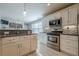 Bright kitchen featuring stainless appliances, granite countertops, and sleek white cabinetry at 557 Bradford Park, Loganville, GA 30052