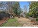 Large, fenced backyard with mature trees, a firepit, and two Adirondack chairs at 2120 Mckinley Nw Rd, Atlanta, GA 30318