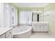 Well-lit main bathroom with soaking tub, large windows, and vanity at 3524 Pine Grove Drive, Douglasville, GA 30135