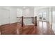 Hallway with hardwood floors featuring wooden railings and stairs, with white walls and trim at 4566 Town Manor Dr, Douglasville, GA 30135