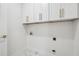 Bright laundry room featuring white cabinetry with gold hardware and marble tile floors at 4566 Town Manor Dr, Douglasville, GA 30135