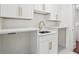 Bright laundry room featuring white cabinets, marble countertops, and gold hardware at 4566 Town Manor Dr, Douglasville, GA 30135