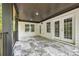 Covered porch with gray tiled floor, featuring gray columns, a wood plank ceiling, and white french doors at 4566 Town Manor Dr, Douglasville, GA 30135