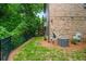 Backyard view with a brick exterior, lush greenery, air conditioning unit, and a black fence at 938 Canterbury Ln, Atlanta, GA 30324