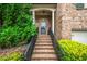 Close up of the charming brick home's front door, front steps, and nicely trimmed front yard at 938 Canterbury Ln, Atlanta, GA 30324