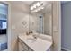 Clean bathroom featuring a single sink vanity with white cabinets, a large mirror, and neutral wall paint at 1683 Wheatstone Dr, Grayson, GA 30017