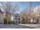 A three-story building with multiple balconies and tall trees offers inviting outdoor spaces at 259 14Th Ne St # 104, Atlanta, GA 30309