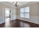 Dining room featuring hardwood floors, modern lighting, and a view of the study through glass-paneled doors at 1348 Rolling Stream Way, Lawrenceville, GA 30043