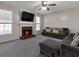 Cozy living room with a brick fireplace, plush carpeting, a ceiling fan, and large windows at 1348 Rolling Stream Way, Lawrenceville, GA 30043