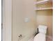 Powder room showing a beige wall and a standard toilet with overhead white shelving at 1510 Mount Mckinley Dr, Grayson, GA 30017