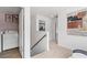 Upstairs hallway with laundry area, linen closet, neutral carpet, and a stairwell at 305 Heavenly Hollow Pl, Mcdonough, GA 30253