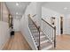 Hallway with stairs featuring a black railing and console table, with light-colored flooring throughout the home at 305 Heavenly Hollow Pl, Mcdonough, GA 30253