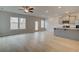 Open living area with wood flooring, fan, natural light and a sleek breakfast bar at 305 Heavenly Hollow Pl, Mcdonough, GA 30253