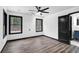 Bedroom with luxury vinyl plank flooring, two windows, a ceiling fan, and a black trimmed door at 3661 W Potomac Dr, East Point, GA 30344