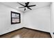 Minimalist bedroom with a ceiling fan, dark trim, and a window offering natural light and simple elegance at 3661 W Potomac Dr, East Point, GA 30344