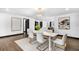 Stylish dining room with sleek white table, modern chairs, and open view to kitchen and entryways at 3661 W Potomac Dr, East Point, GA 30344