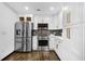 Modern kitchen with white cabinetry, stainless steel appliances, and dark hardwood floors at 3661 W Potomac Dr, East Point, GA 30344