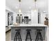 Kitchen island with bar stools, gold faucet and stainless steel refrigerator in modern white kitchen at 3661 W Potomac Dr, East Point, GA 30344