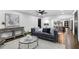 Bright living room with grey sofa, hardwood floors, and open layout to the kitchen at 3661 W Potomac Dr, East Point, GA 30344