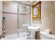 Bathroom featuring a shower with glass doors, tile surround, and pedestal sink at 215 Piedmont St # 1204, Atlanta, GA 30308