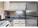 Cozy kitchen features white cabinetry, black countertops, and stainless steel appliances at 215 Piedmont St # 1204, Atlanta, GA 30308