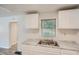 A view of the stainless steel sink and white countertops in the bright and naturally lit kitchen at 3459 Adkins Nw Rd, Atlanta, GA 30331