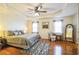 Spacious bedroom featuring tray ceiling, ceiling fan, hardwood floors, and a decorative rug at 7740 Berea Rd, Winston, GA 30187