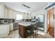 Well-lit kitchen features stainless appliances, granite counters, kitchen island with seating, and tile floors at 7740 Berea Rd, Winston, GA 30187