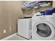 Functional laundry room with a washing machine, dryer, and storage shelves, ideal for efficient home maintenance at 1070 River Valley Dr, Dacula, GA 30019