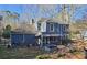 Backyard view showing a covered patio with a hot tub, green grass, and various trees at 744 Dean Way, Lawrenceville, GA 30044