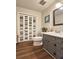 Updated bathroom featuring wood-look floors, gray cabinets, a toilet and a sink at 744 Dean Way, Lawrenceville, GA 30044