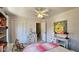 Comfortable bedroom with a ceiling fan, closet, and a whimsical Winnie the Pooh painting, offering a playful space at 744 Dean Way, Lawrenceville, GA 30044