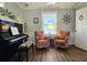 Cozy living room featuring a piano and two comfortable armchairs by a sunlit window at 744 Dean Way, Lawrenceville, GA 30044