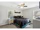 Cozy bedroom featuring carpet, ceiling fan, a large window and black bedding at 992 Yemassee Trl, Stone Mountain, GA 30083