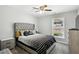 Bedroom features a bed with cushioned headboard, ceiling fan, and neutral carpet at 992 Yemassee Trl, Stone Mountain, GA 30083