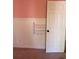 Charming pink bedroom featuring wainscoting details and a convenient wall rack next to the door at 509 Arnold Road, Lawrenceville, GA 30044