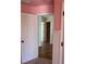 Hallway view showcasing hardwood floors and light pink walls, creating a harmonious transition between spaces at 509 Arnold Rd, Lawrenceville, GA 30044