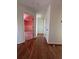 Hallway features hardwood flooring and a view into a light pink bedroom, creating an inviting and cozy atmosphere at 509 Arnold Road, Lawrenceville, GA 30044