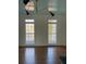 Light-filled room featuring hardwood floors, white trim, blue ceiling and two large windows with a modern light fixture at 509 Arnold Road, Lawrenceville, GA 30044