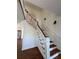 Elegant staircase with wood steps, white railings, and a decorative chandelier; stainless steel refrigerator in background at 509 Arnold Rd, Lawrenceville, GA 30044