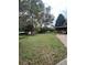 Large backyard with green grass and mature trees with side carport at 5157 West St, Covington, GA 30014