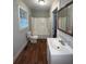 Bathroom with tiled shower/tub, toilet, vanity, and wood-look floors at 5157 West St, Covington, GA 30014