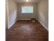 Empty bedroom with neutral walls, window, and wood-look flooring at 5157 West St, Covington, GA 30014